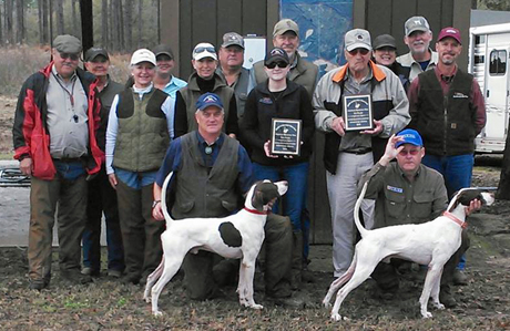 Tim Moore, on left, poses third place Elhew G Force while Sedge Surfer, winner of the stake, is on right. Standing behind Surfer and holding the plaque is his owner, Field Trial Hall-of-Famer Bill Perry. Jim Tande is the tall guy wearing a tan hat in the center of the back row.